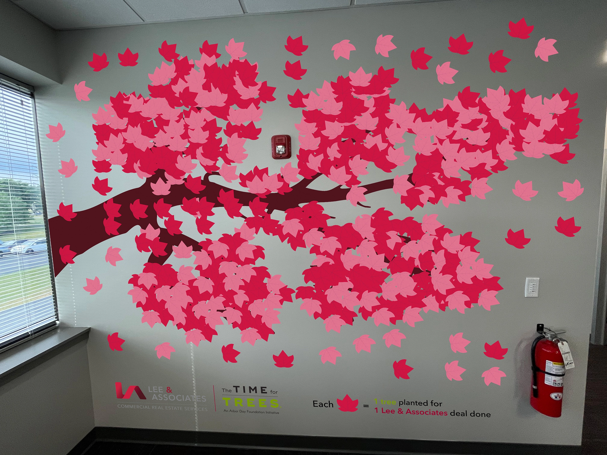 Wall graphic showing leaves being placed for each tree planted for each commercial deal done